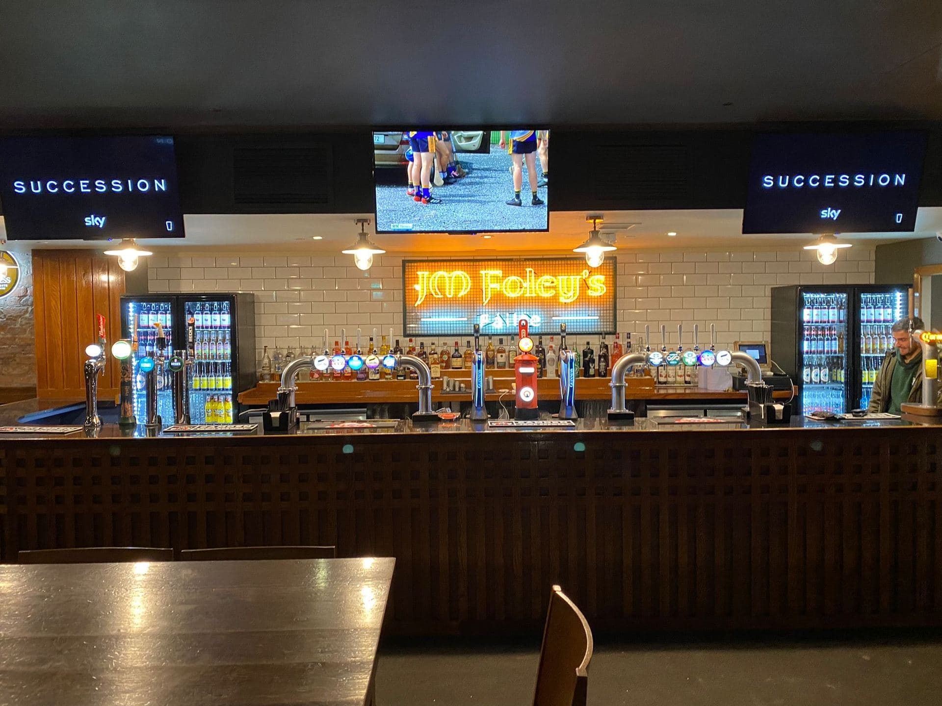 JM Foley's bar with overhead TVs and back-lit signage